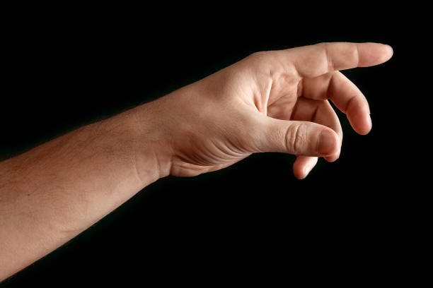 istock Man's hand touching or pointing to something isolated on black background. Close up. High resolution. 1135816787
