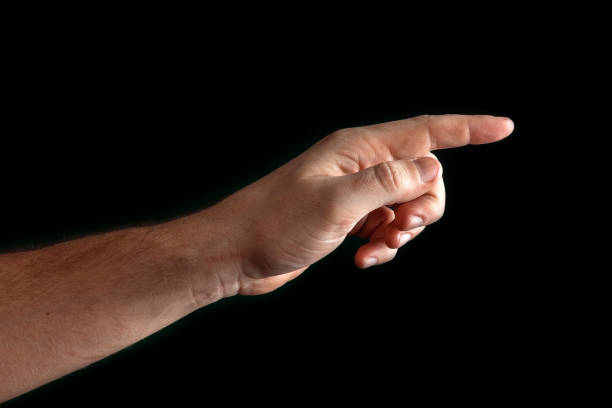 istock Man's hand touching or pointing to something isolated on black background. Close up. High resolution. 1135816806