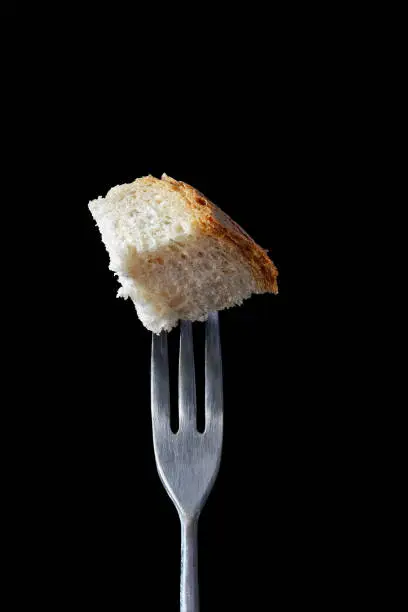 Food on Fondue Fork Series: bread, isolated against black background