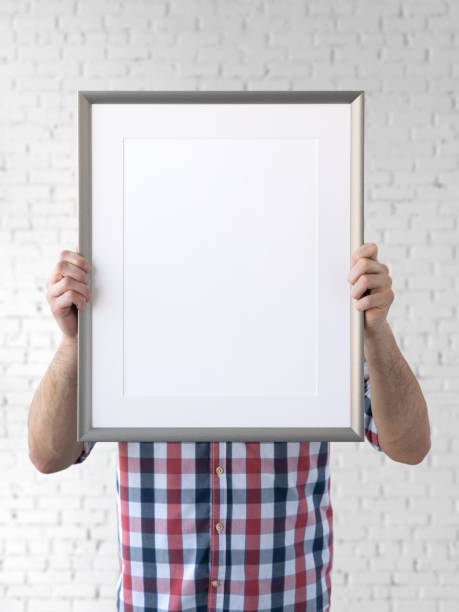istock Holding frame mockup. Photo Mockup. The man hold frame. For frames and posters design. Frame size 12x16 (30x40cm). 1135826786