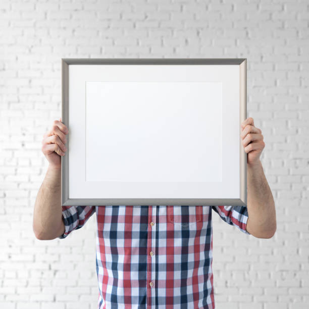 istock Holding frame mockup. Photo Mockup. The man hold frame. For frames and posters design. Frame size 16x12 (40x30cm). 1135826819