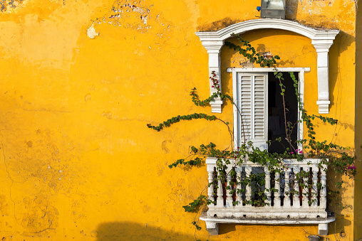 Old colonial balcony in a historic yellow building in Cartagena, Colombia