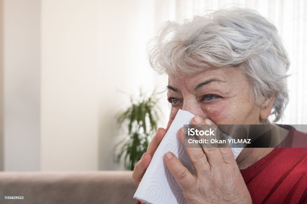 Sick at home The old woman who is sick at home takes some medicine and traditional drinks for health. 60-69 Years Stock Photo