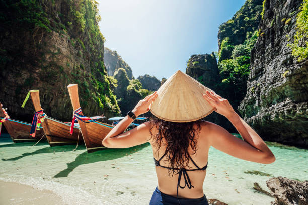 istock Young woman on a beautiful beach in Thailand with longtail boats, Phi Phi Island 1135834021