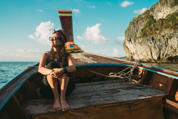 istock Young woman on a longtail boat in Thailand during sunset, Phi Phi Island 1135834041