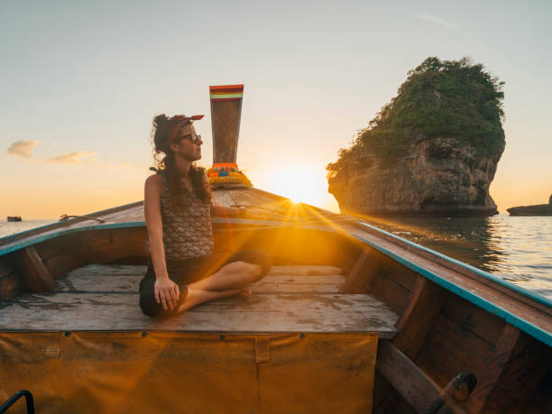 istock Young woman on a longtail boat in Thailand during sunset, Phi Phi Island 1135834047