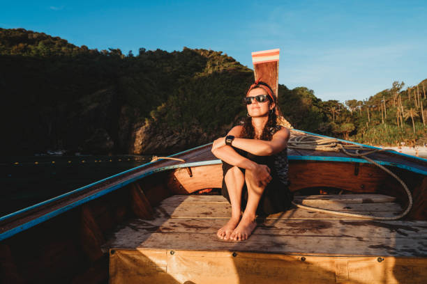 istock Young woman on a longtail boat in Thailand during sunset, Phi Phi Island 1135834050