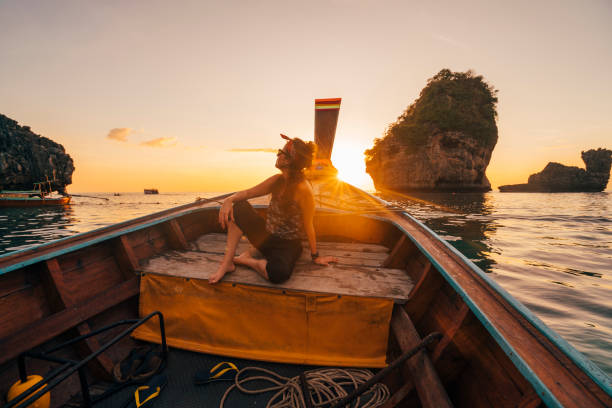 istock Young woman on a longtail boat in Thailand during sunset, Phi Phi Island 1135834052