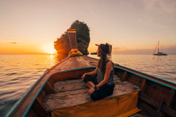 istock Young woman on a longtail boat in Thailand during sunset, Phi Phi Island 1135834056