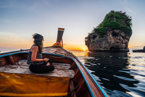 istock Young woman on a longtail boat in Thailand during sunset, Phi Phi Island 1135834062
