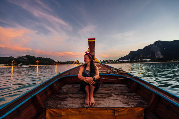 istock Young woman on a longtail boat in Thailand during sunset, Phi Phi Island 1135834066
