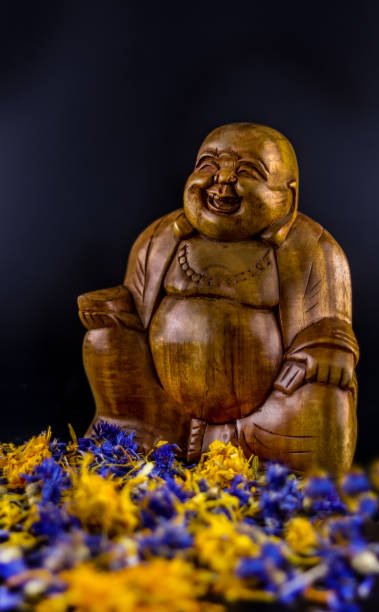istock wooden buddha statue decorated with flowers 1135835324