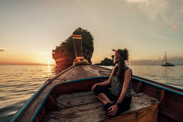 istock Young woman on a longtail boat in Thailand during sunset, Phi Phi Island 1135835391