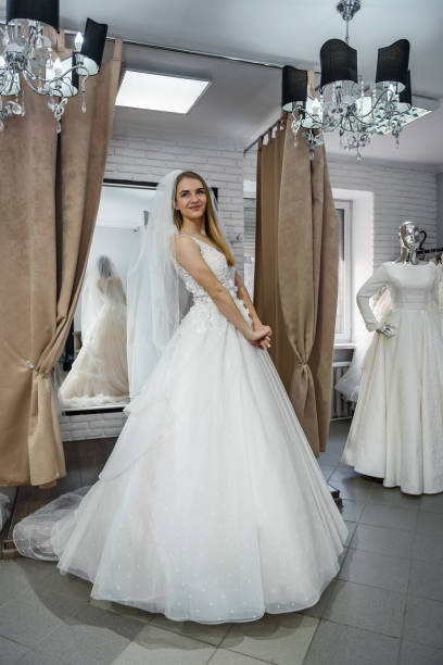 istock Smiling bride fitting dress in wedding salon 1135835485