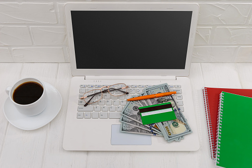 Laptop, credit card, dollars and coffee cup