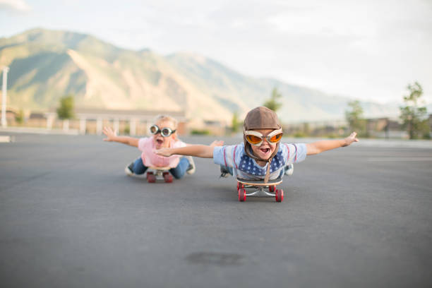 young boy and girl flying on skateboards - teamwork occupation creativity taking off imagens e fotografias de stock