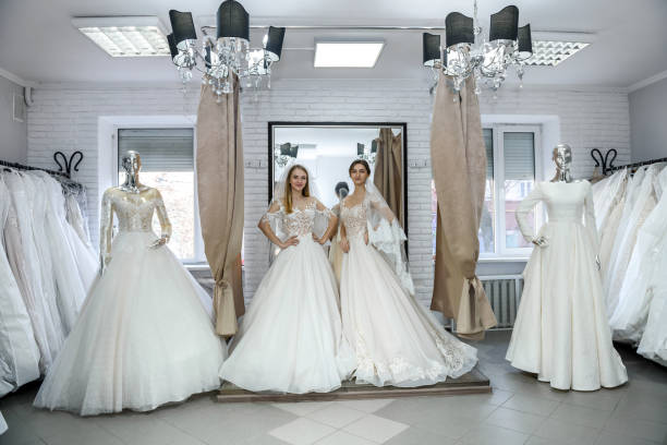 istock Two happy women in wedding dresses posing in salon 1135838005