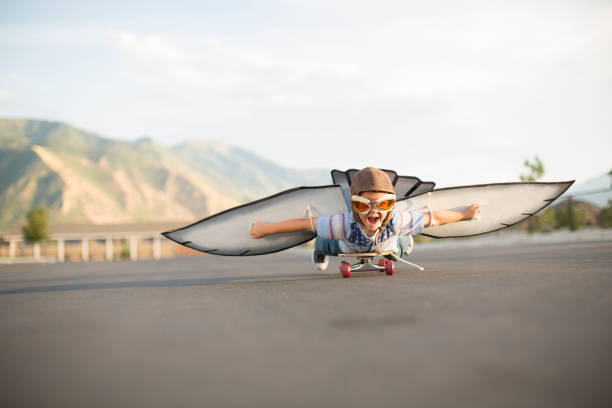 翼を持つスケートボードを飛ぶ若い少年 - action adventure aerospace industry air vehicle ストックフォトと画像