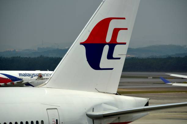 Two Malaysia Airlines aircraft cross at Kuala Lumpur International Airport (KLIA), Malaysia Kuala Lumpur, Malaysia: two Malaysia Airlines jets taxiing at Kuala Lumpur International Airport (KLIA) - forest and hills in the background, Sepang, Selangor kuala lumpur airport stock pictures, royalty-free photos & images