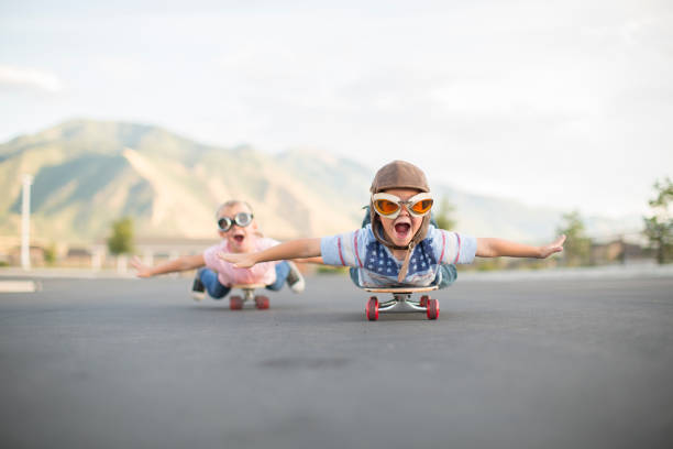 young boy und girl flying auf skateboards - abheben aktivität fotos stock-fotos und bilder
