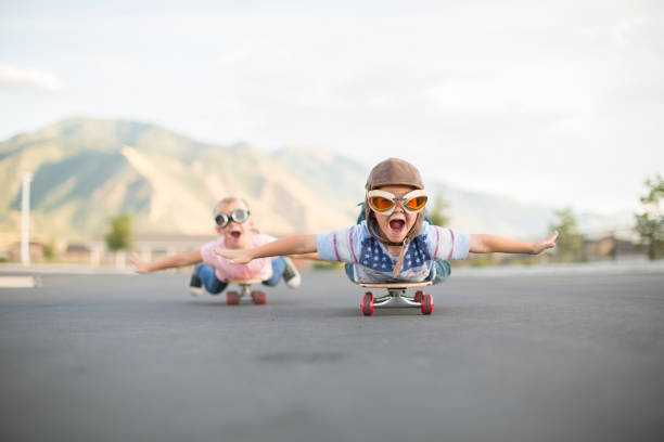 young boy and girl flying on skateboards - teamwork occupation creativity taking off imagens e fotografias de stock