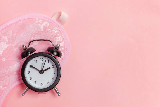 istock Sleeping mask and alarm clock on pink background 1135839465