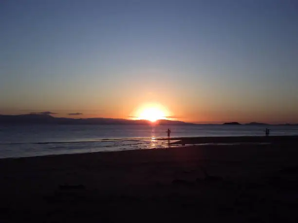 Silhouette of people fishing on the beach