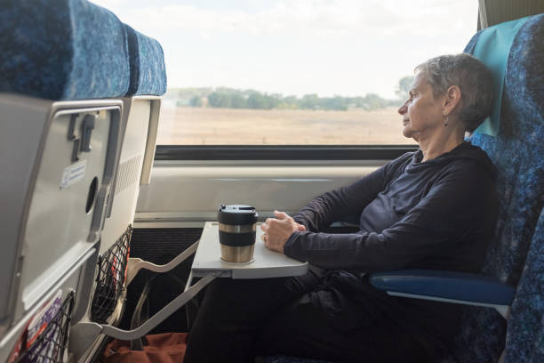 istock Senior woman sitting in train seat with reusable mug 1135843914