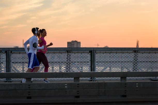 istock Young man and woman jogging together along bridge 1135844034