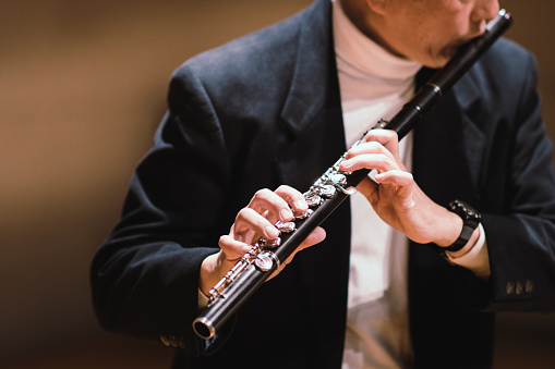 Gentleman playing flute in classical music concert