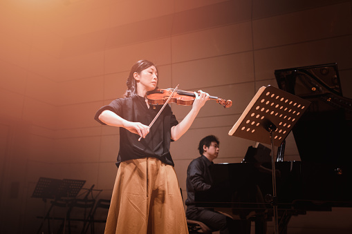 Musicians playing violin and piano at classical music concert