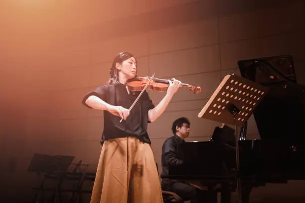 Photo of Musicians playing violin and piano at classical music concert