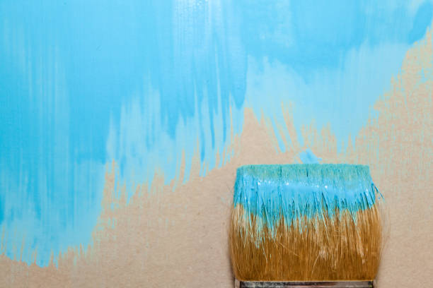 istock paint brush in blue paint on an unpainted flat surface, copyspace 1135847750