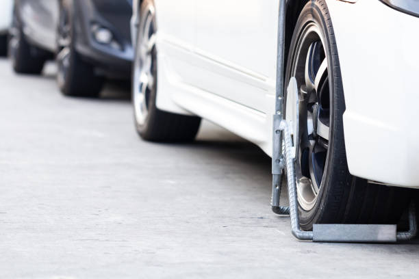 istock Car wheel blocked by wheel lock with illegal parking violation. 1135848773