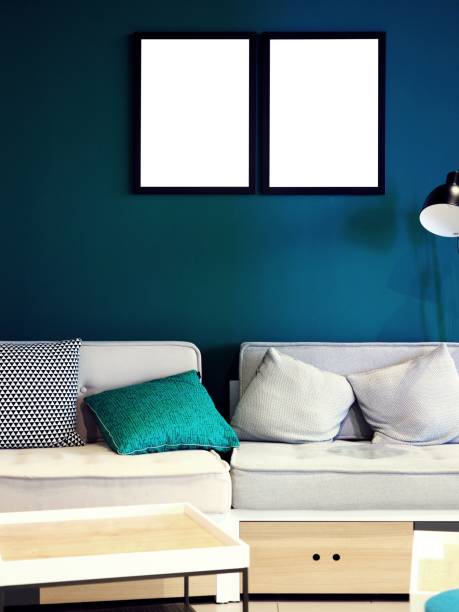 istock Mock-up, mockup exhibition, modern creative hipster living room, studio, office with sofa with pillows, couch and lamp, white empty photo frame on a solid color, green blue wall and white wooden desk 1135849425