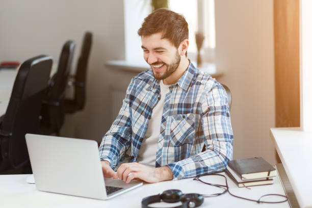 istock Happy man using laptop at table in office 1135856553