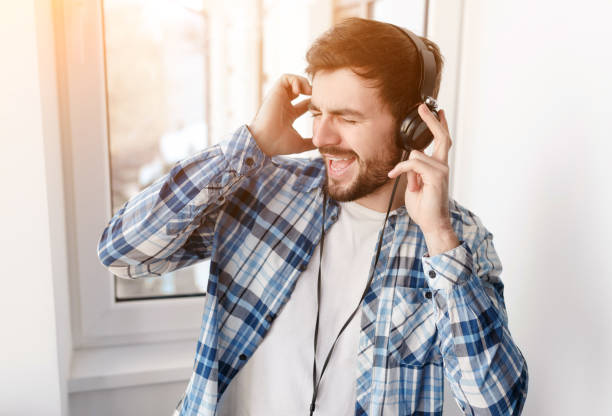 istock Bearded man in headphones singing with music 1135856579