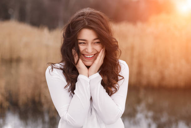 istock Beautiful laughing brunette with hands on cheeks 1135856597
