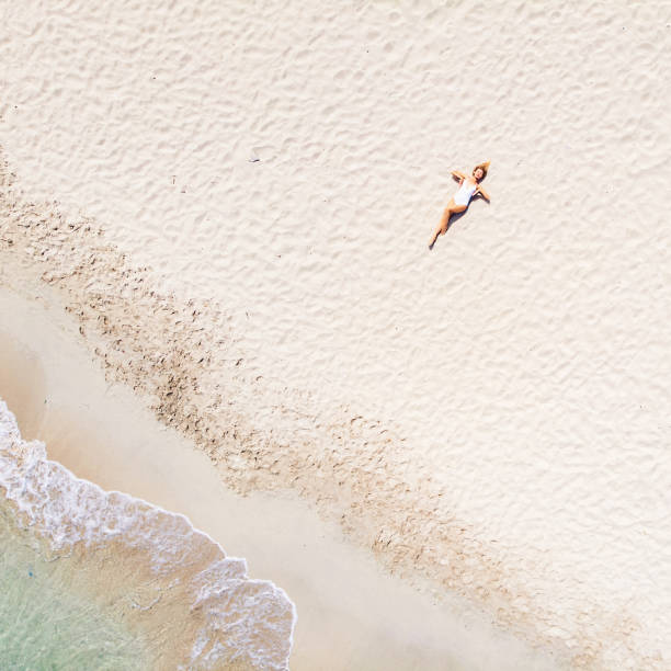 istock Beautiful Woman Lying on Sand at the Beach 1135859871