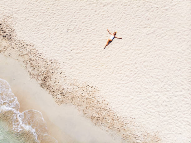 istock Beautiful Woman Lying on Sand at the Beach 1135859889