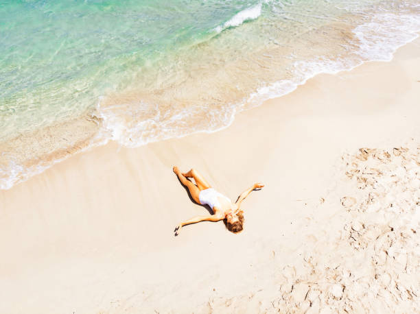istock Beautiful Woman Lying on Sand at the Beach 1135859928