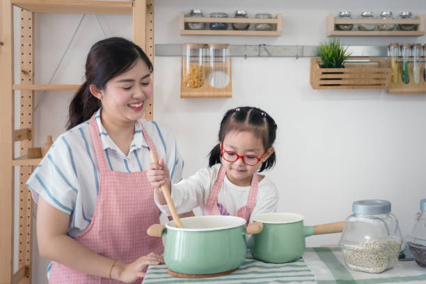 istock mother teaching little daughter learning how to cook in kitchen 1135862098