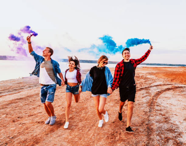 istock young friends running with hand flare or fusee 1135864679