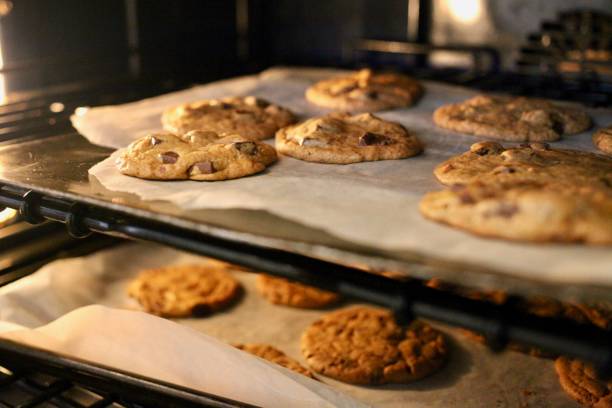 Fresh chocolate chip cookies being baked in an oven stock photo
