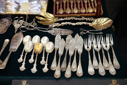 Antique silver Cutlery, spoons, forks, knives on the shelf of the flea market.