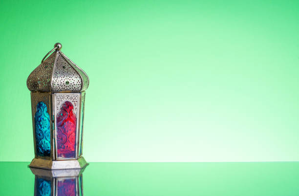 Ramadan lantern or Arabic decoration lamp on green background. Selective focus
