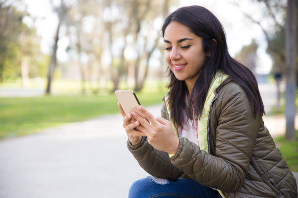 istock Smiling young woman texting sms on smartphone 1135880990
