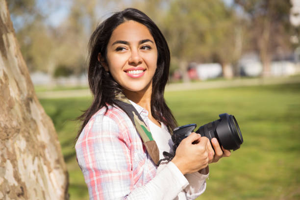 istock Cheerful smiling young photographer posing with camera 1135881001