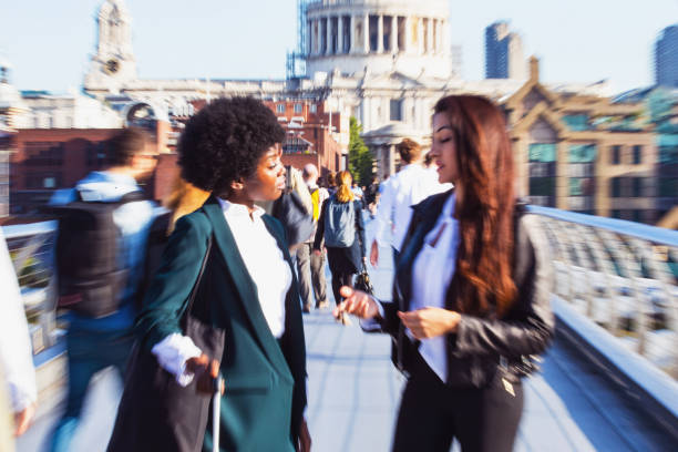 Female Business Peers Rushing to Office London, Businesswoman, Confidence, Female - Girls having casual conversation while walking towards their office city zoom out stock pictures, royalty-free photos & images