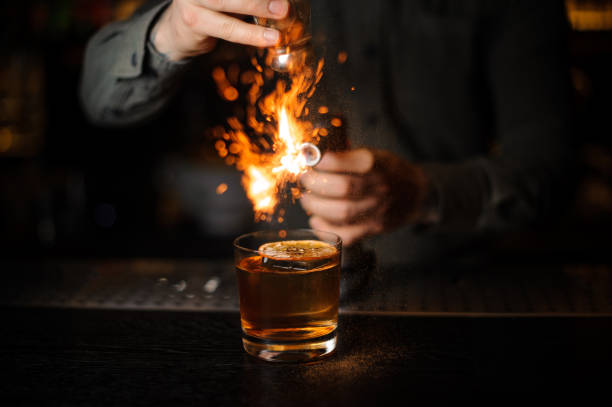 istock Bartender adding to a cocktail brown spice and flaming it 1135892419